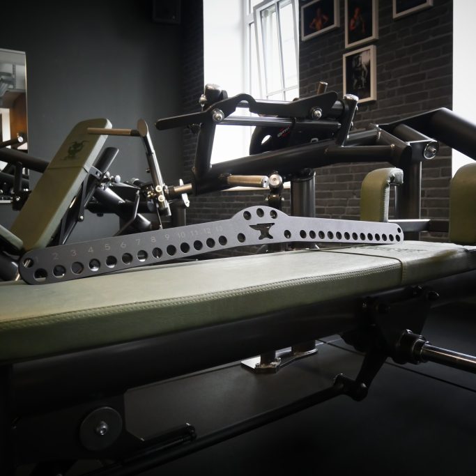 Ein Fitnessgerät mit verstellbarer Bank und strukturiertem Hintergrund.