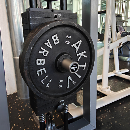Schwarzes Gewicht auf einer Hantel in einem Fitnessstudio.