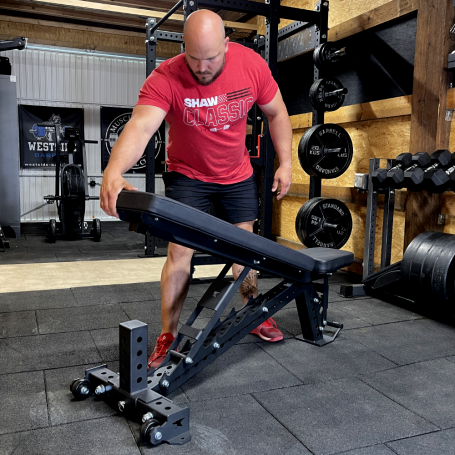 Mann passt eine Trainingsbank im Fitnessstudio an.